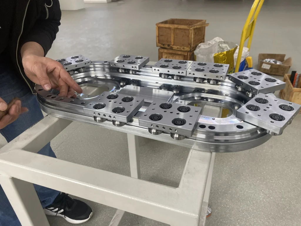 A technician working on the carriage and return section of an oval track assembly