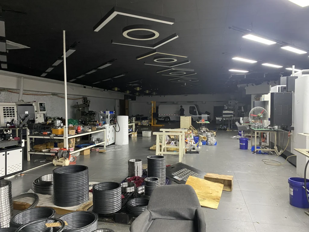 Wide workshop view with production equipment, benches and circular rail components