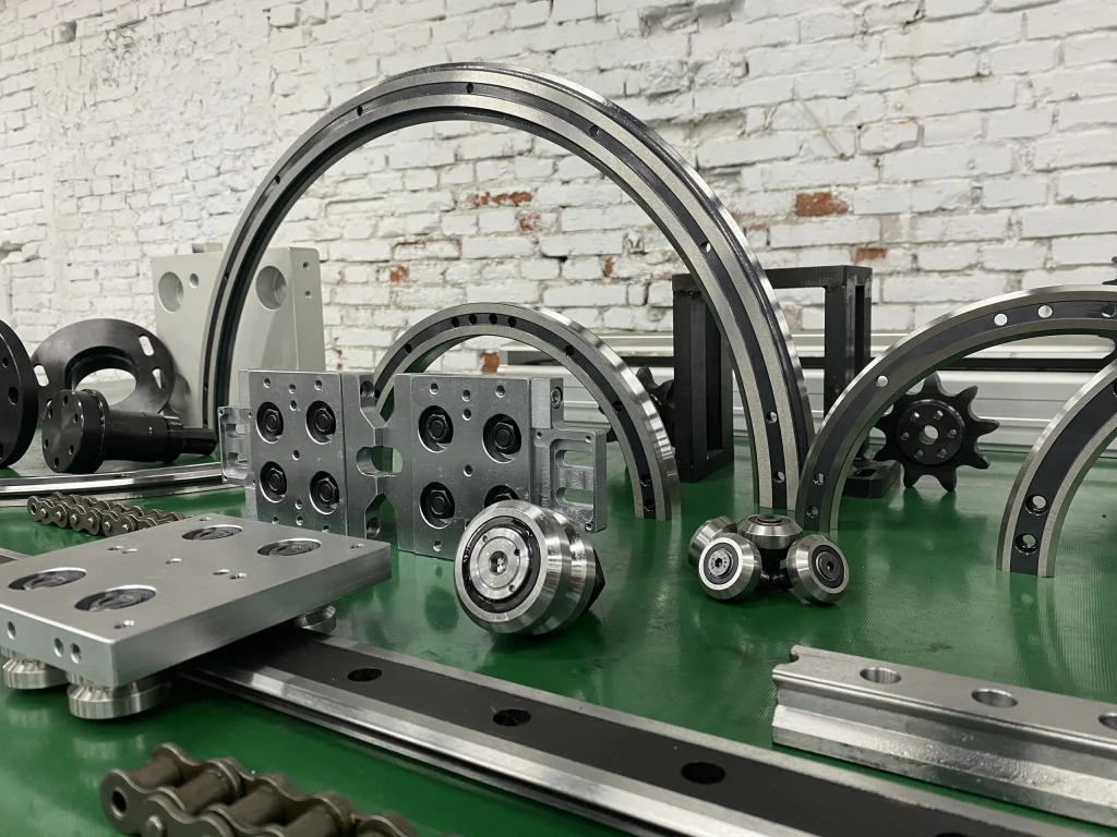 Circular guide rails, rollers and carriage components arranged on a green workbench