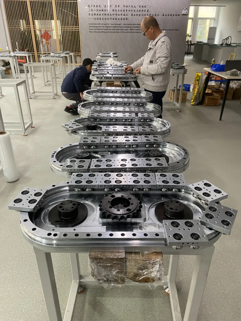 Technicians working beside a row of compact oval track modules